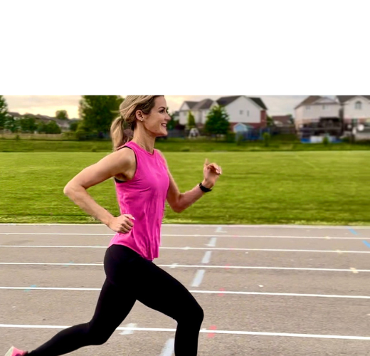 girl in pink tank running on track outside